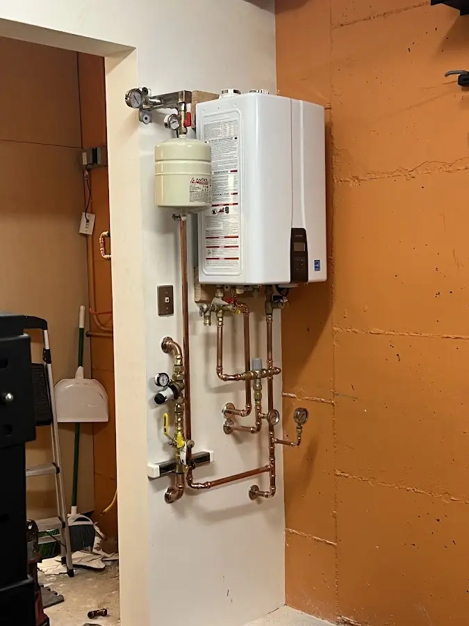 Plumbing technician inspecting water heater connections in Lincolnwood